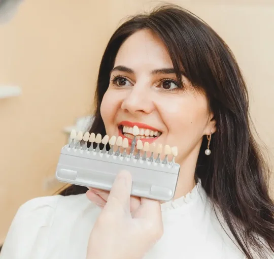 Dr. Sison shade-matching porcelain veneers to a patient's natural teeth