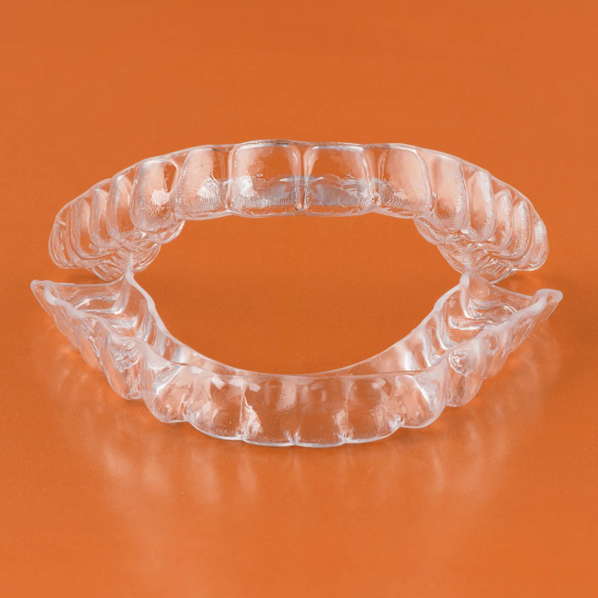 Patient holding a clear aligner up to the light